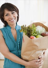 Hispanic woman carrying groceries