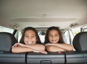 Hispanic sisters in back seat of car