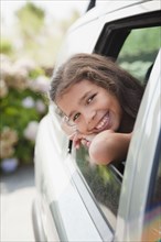 Hispanic girl smiling out car window