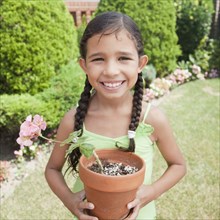 Hispanic girl holding potted plant