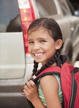 Smiling Hispanic girl carrying backpack