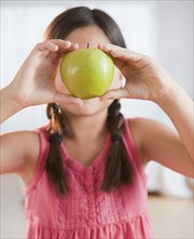Mixed race girl holding green apple
