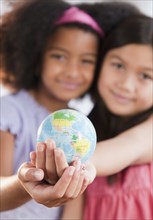 Girls holding globe together