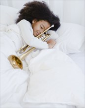 Hispanic girl sleeping with trumpet
