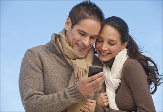 Hispanic couple looking at cell phone