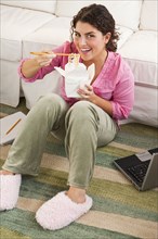 Mixed race woman eating take-out