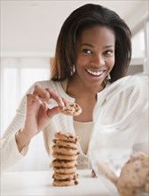 Mixed race woman taking cookie