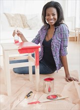 Mixed race woman painting table