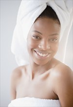 Smiling mixed race woman with head in towel
