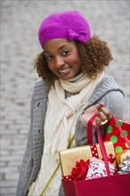 Mixed race woman carrying Christmas gifts