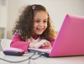 Hispanic girl using colorful laptop