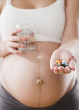 Pregnant Hispanic woman with handful of pills
