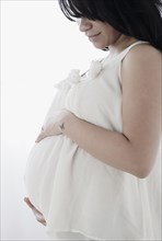Pregnant Hispanic woman holding stomach