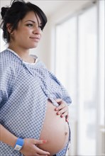 Pregnant Hispanic woman in hospital gown