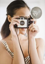 Mixed race woman using old-fashioned camera