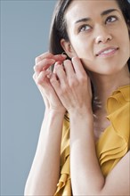 Mixed race woman putting on earrings
