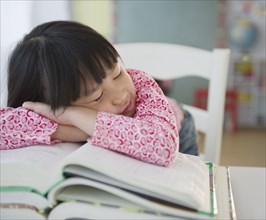 Chinese girl napping on textbooks
