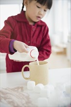 Chinese girl making hot chocolate