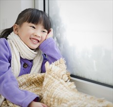 Chinese girl with blanket looking out window