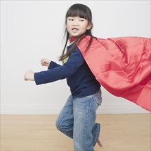 Chinese girl superhero running with cape