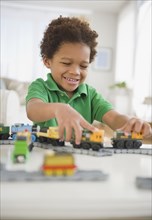 Black boy playing with toy trains