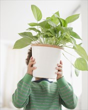 Black boy carrying potted plant