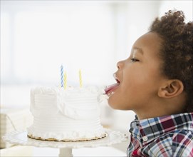 Black boy licking birthday cake