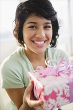 Hispanic woman holding birthday gift
