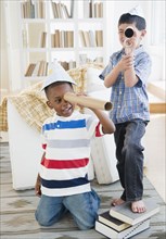 Boys playing with paper hats and cardboard telescopes