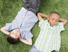 Boys sleeping in grass