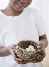 Black boy holding nest with bird's eggs