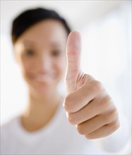 Mixed race woman giving thumbs up sign