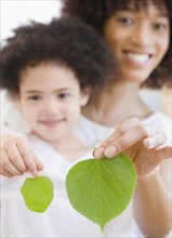 Mother and daughter holding green leaves