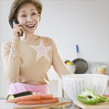 Japanese woman using telephone in kitchen