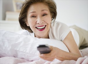 Japanese woman watching television in bed