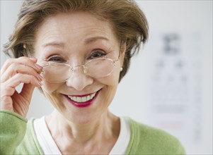 Japanese woman holding eyeglasses