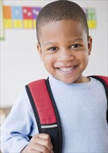 African American boy wearing backpack in school