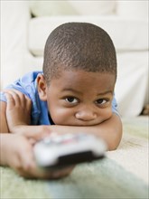 African American boy laying on floor watching television