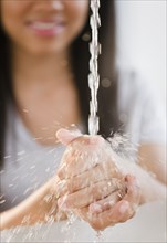 Close up of mixed race teenage girl washing hands in water