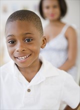 Smiling Black boy with mother in background