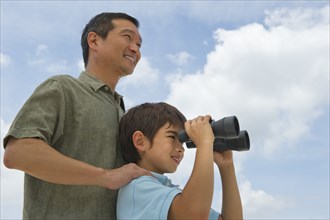 Father with son looking through binoculars