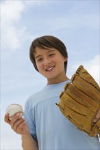 Smiling mixed race boy with baseball and mitt