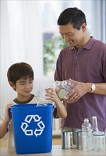 Father and son recycling plastic bottles and tin cans