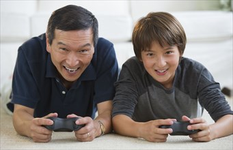 Father and son playing video game on living room floor