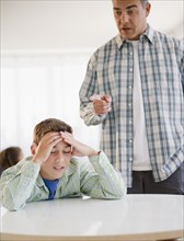 Hispanic father lecturing frustrated son