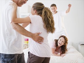 Laughing Hispanic family playing together