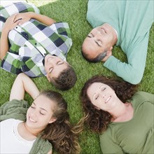 Hispanic family laying in grass together