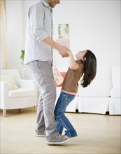 Daughter standing on father's feet and dancing
