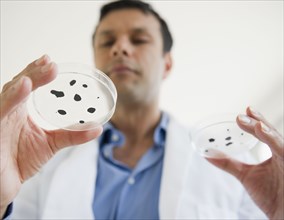 Mixed race researcher holding specimen in petri dish