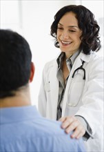 Hispanic doctor talking to patient in doctor's office